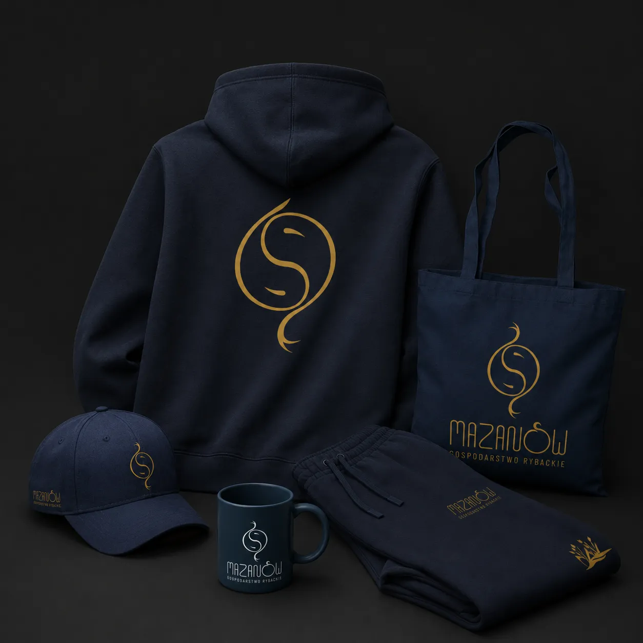 A set of Mazanów company merch on a dark background – a hoodie with the signet on the back, a bag, a cap, a mug and sweatpants