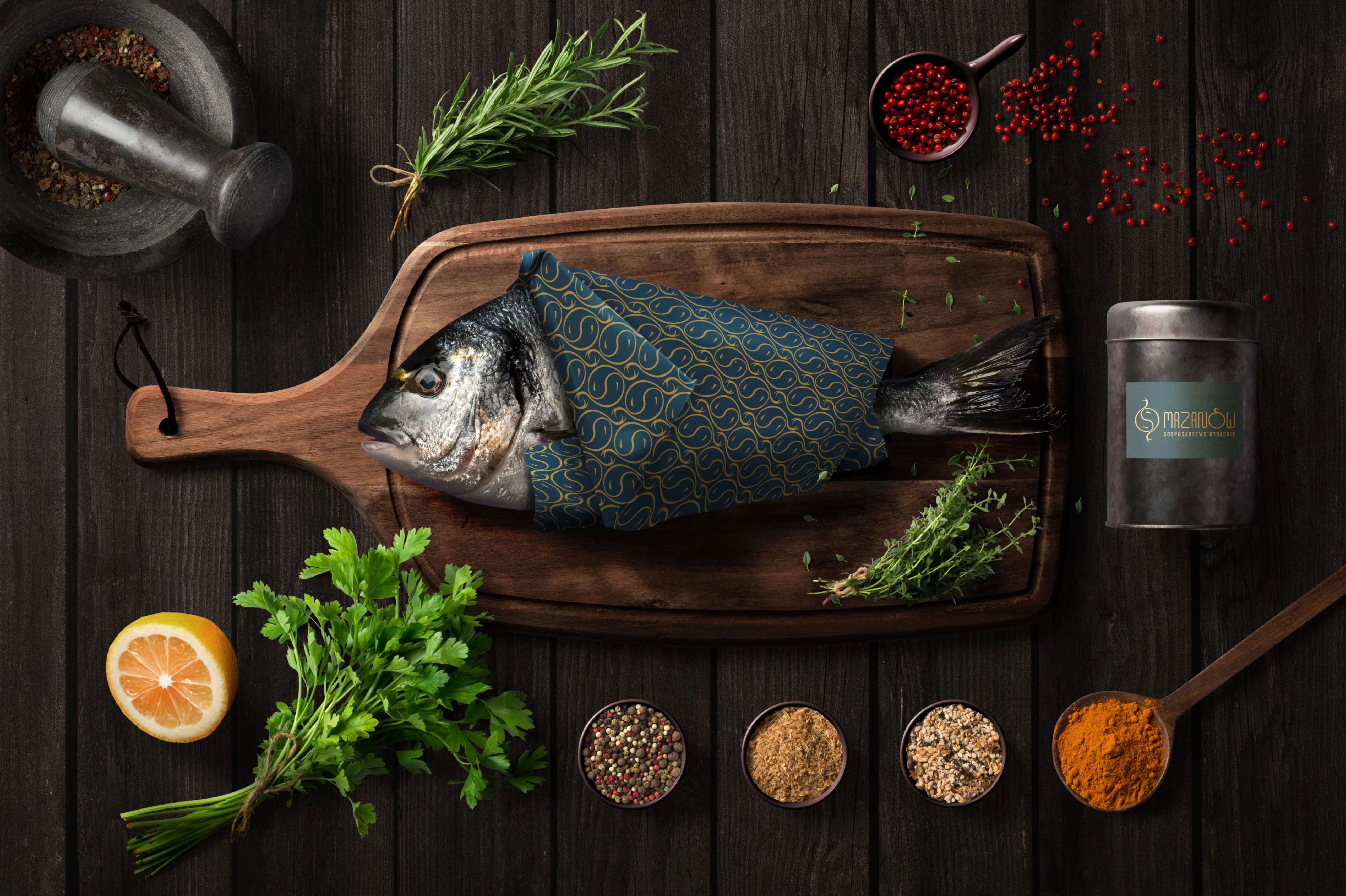 Visualisation of a fish wrapped in Mazanów branded paper beside a labelled jar, on a wooden surface