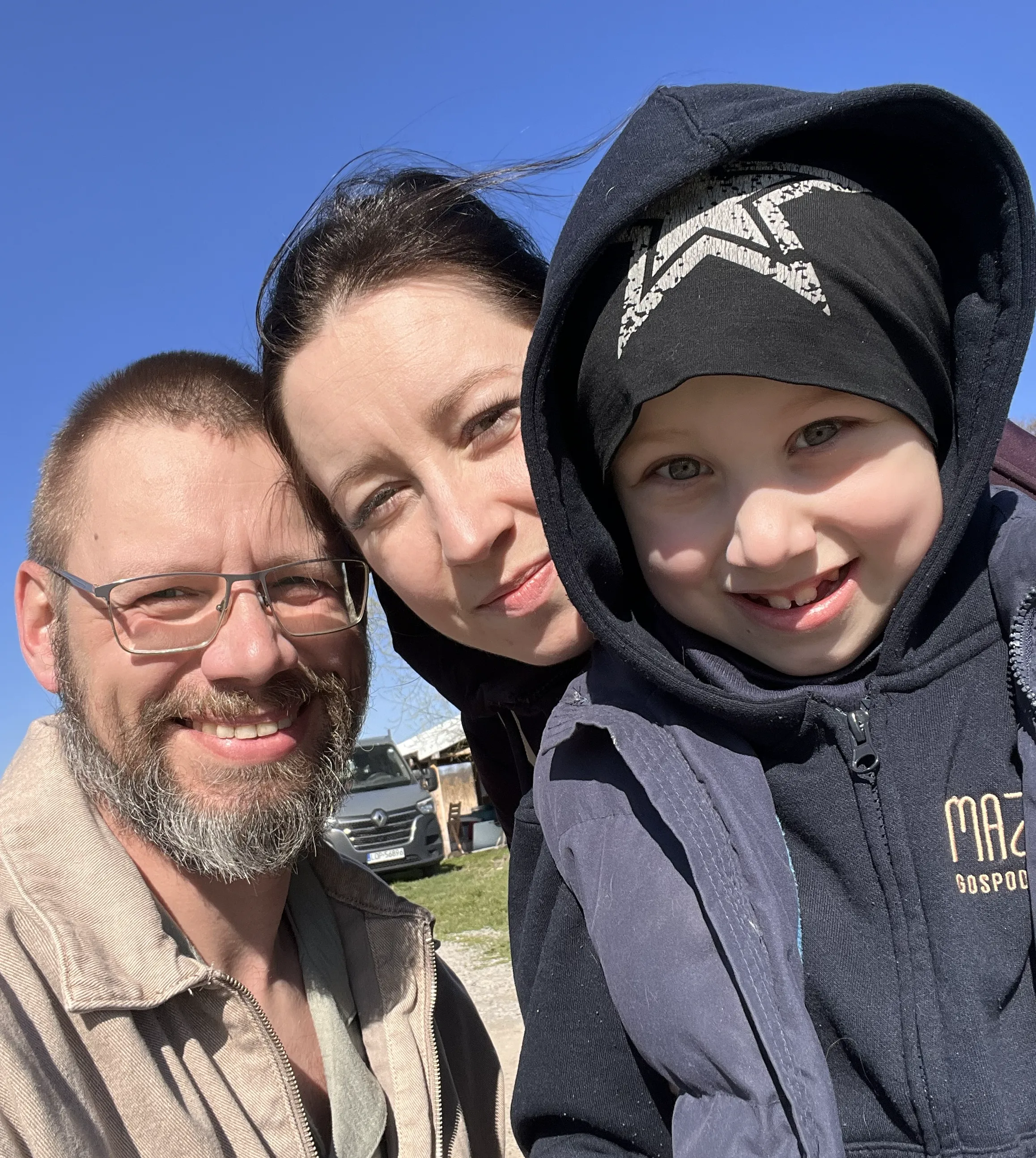 Justyna and Michał Nowak, owners of Mazanów Fish Farm, with their child in a hoodie bearing the farm logo